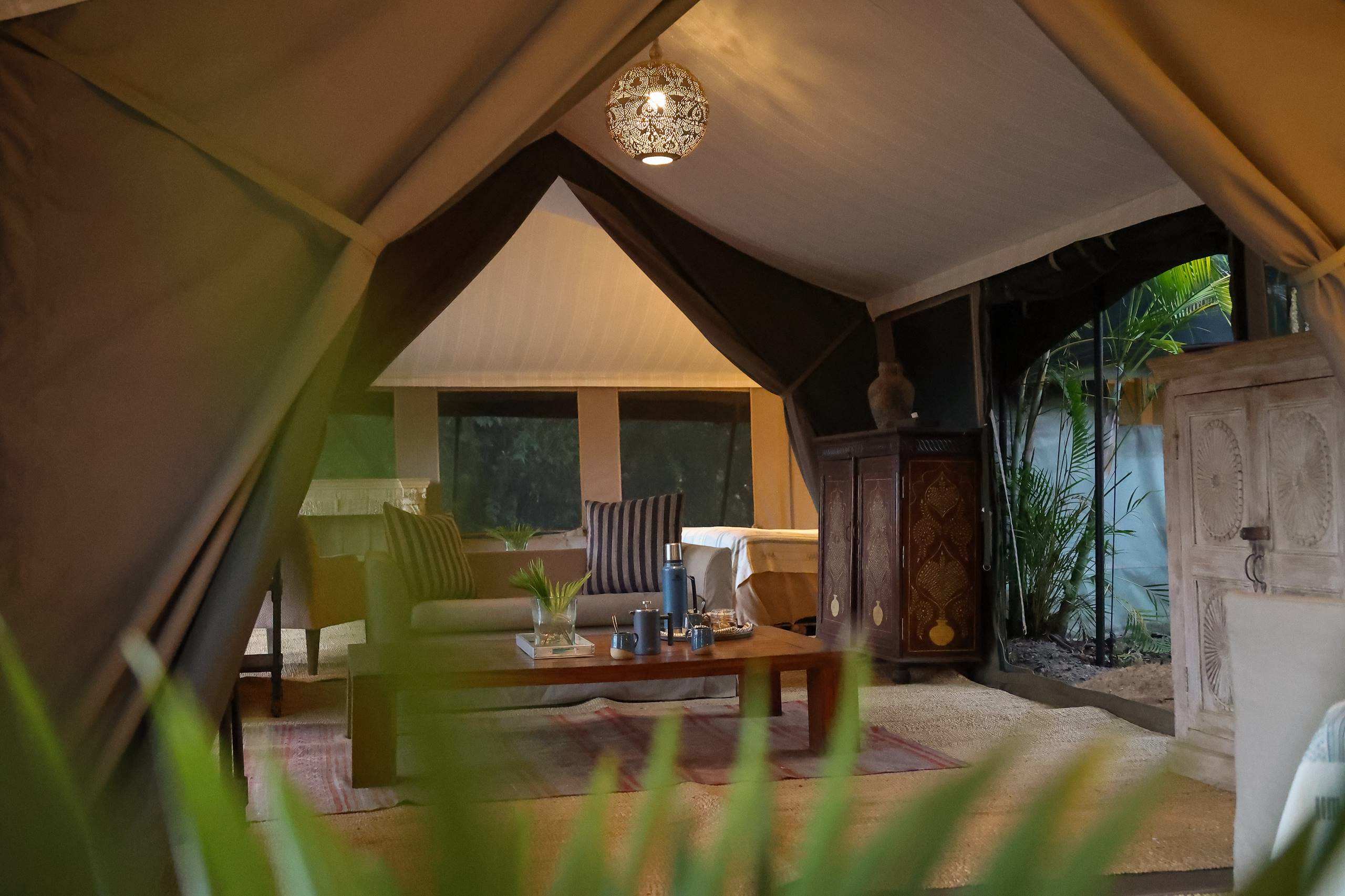 Tented Suite Interior: The meticulous interior refresh at River Camp Mara blends heritage charm with modern luxury. This view of the tented lounge shows the new tactile design vocabulary, featuring bespoke Nairobi-printed textiles and handcrafted elements from local Mara artisans.