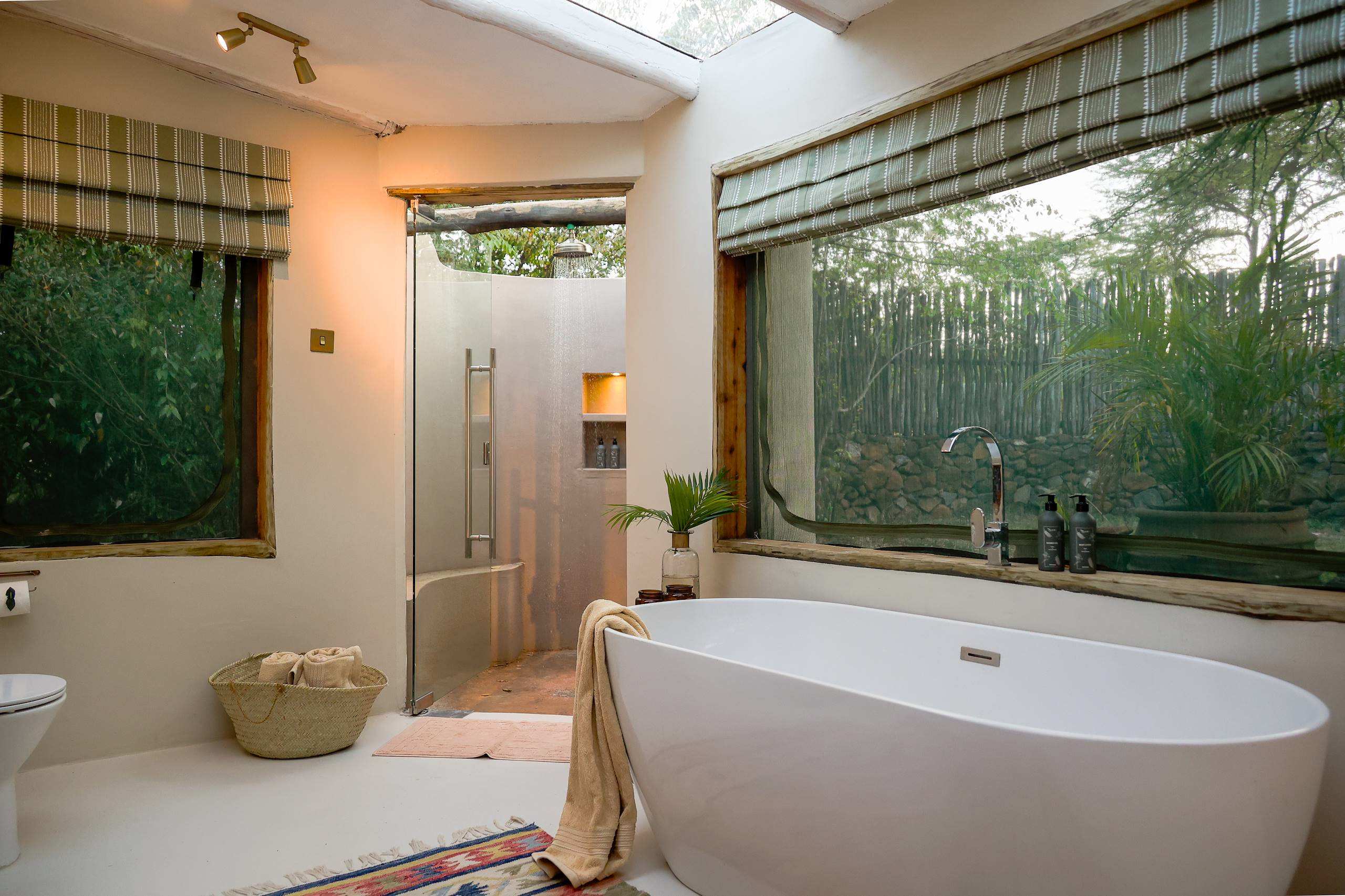 En-suite Bathroom: The upgraded en-suite bathrooms at River Camp Mara combine luxury standards with a connection to nature. This space features high-end fixtures alongside sustainable infrastructure upgrades, such as new solar water heating systems.