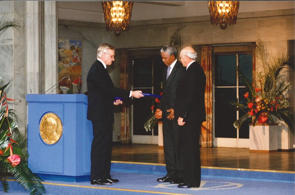 Nelson Mandela and F.W. de Klerk receiving their Nobel Prize medals and diplomas from Francis Sejersted, Chairman of the Norwegian Nobel Committee at the Nobel Peace Prize award ceremony, 10 December 1993. Knudsens fotosenter/Dextra Photo, Norsk Teknisk Museum