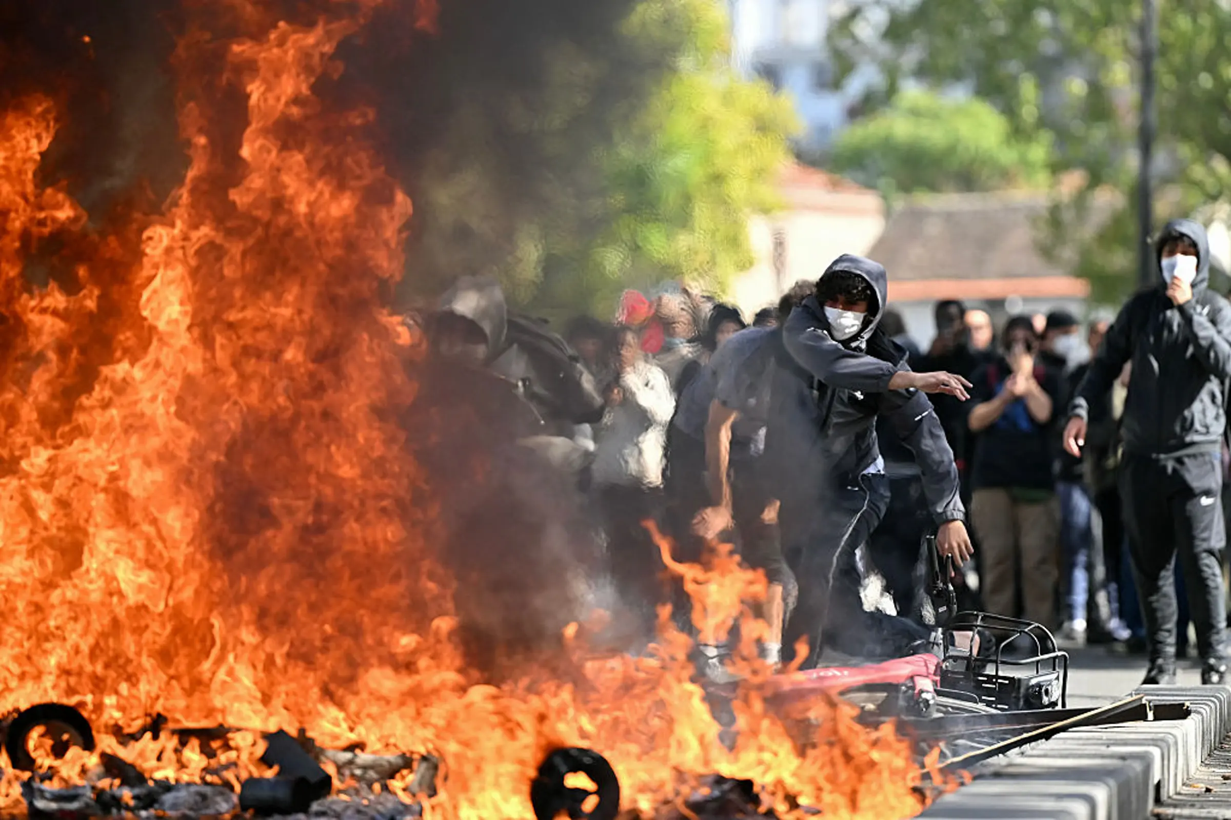 A protesting student feeds a burnt barrier during a blockading action outside the secondary school Le Corbusier, in Aubervilliers, northern Paris on October 1, 2026. Lou Benoist—AFP/Getty Images